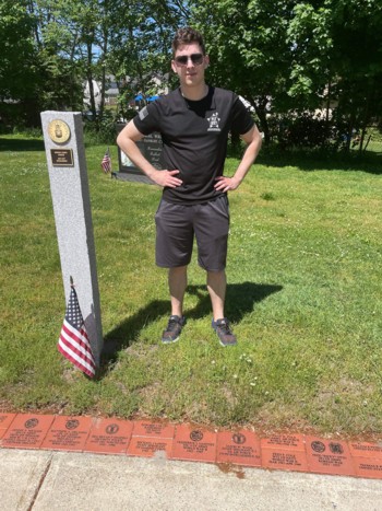 Jason Wade, Staff Sergeant with the 375th Intelligence Squadron, US Air Force, standing next to his brick for Memorial Day 2021.  The brick was donated by his mom, Michele Wade.