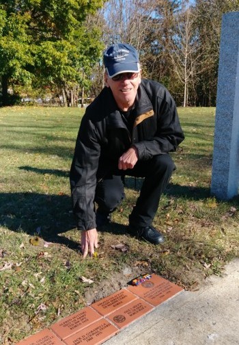 Vietnam War veteran John Schroeder kneels next to his brick in the walkway after the Veterans Day Ceremony at the Danbury War Memorial on November 11, 2017.  Schroeder was a Radarman 2nd Class aboard the USS Lofberg.  The brick was donated by his son and daughter in his honor.
